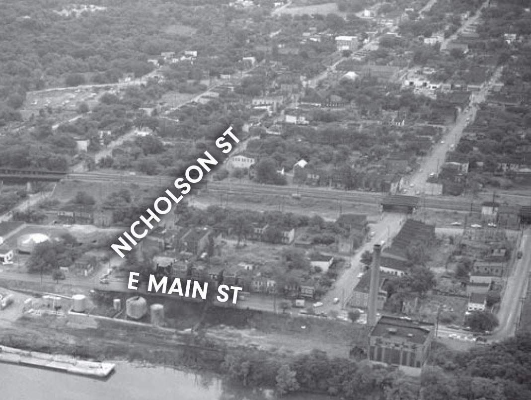 This is a black and white photo of Fulton Bottom with the James in the foreground and a gridded urban street pattern neighborhood in the remaining space.. 