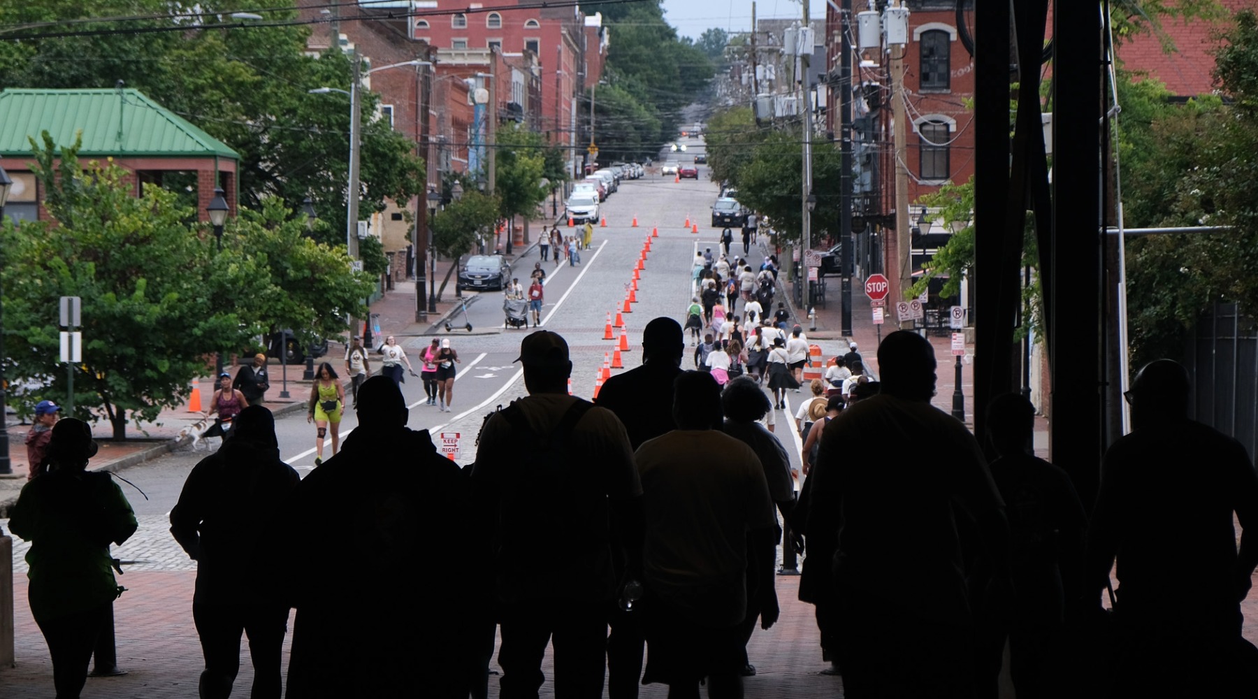 People backlit under the Main Street Station overpass