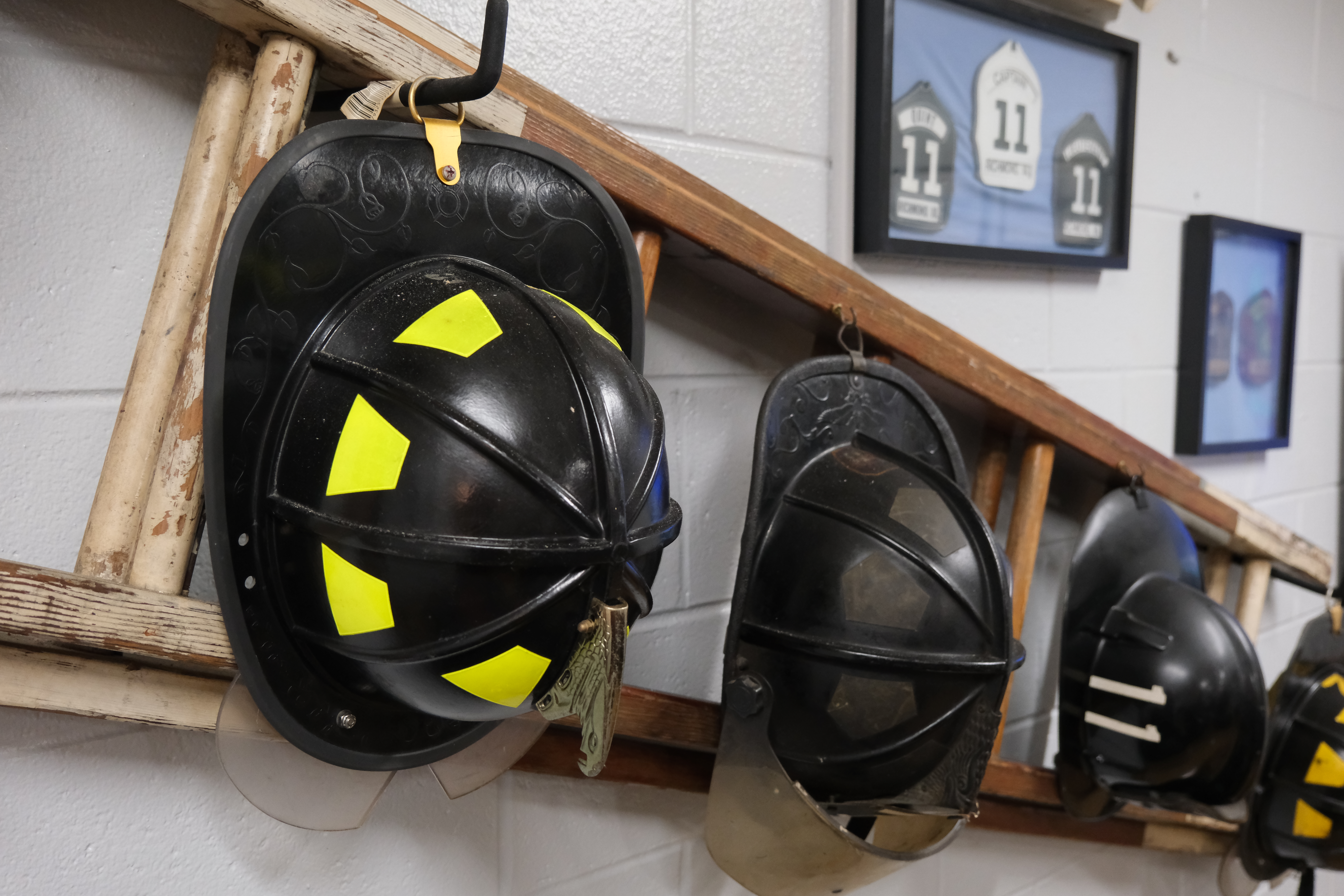 Firefighter helmets hanging on a ladder