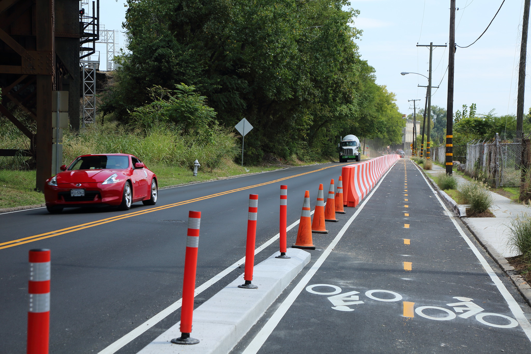 this image show a two way bike lane with orange dividers separating the lanes from vehicle traffic