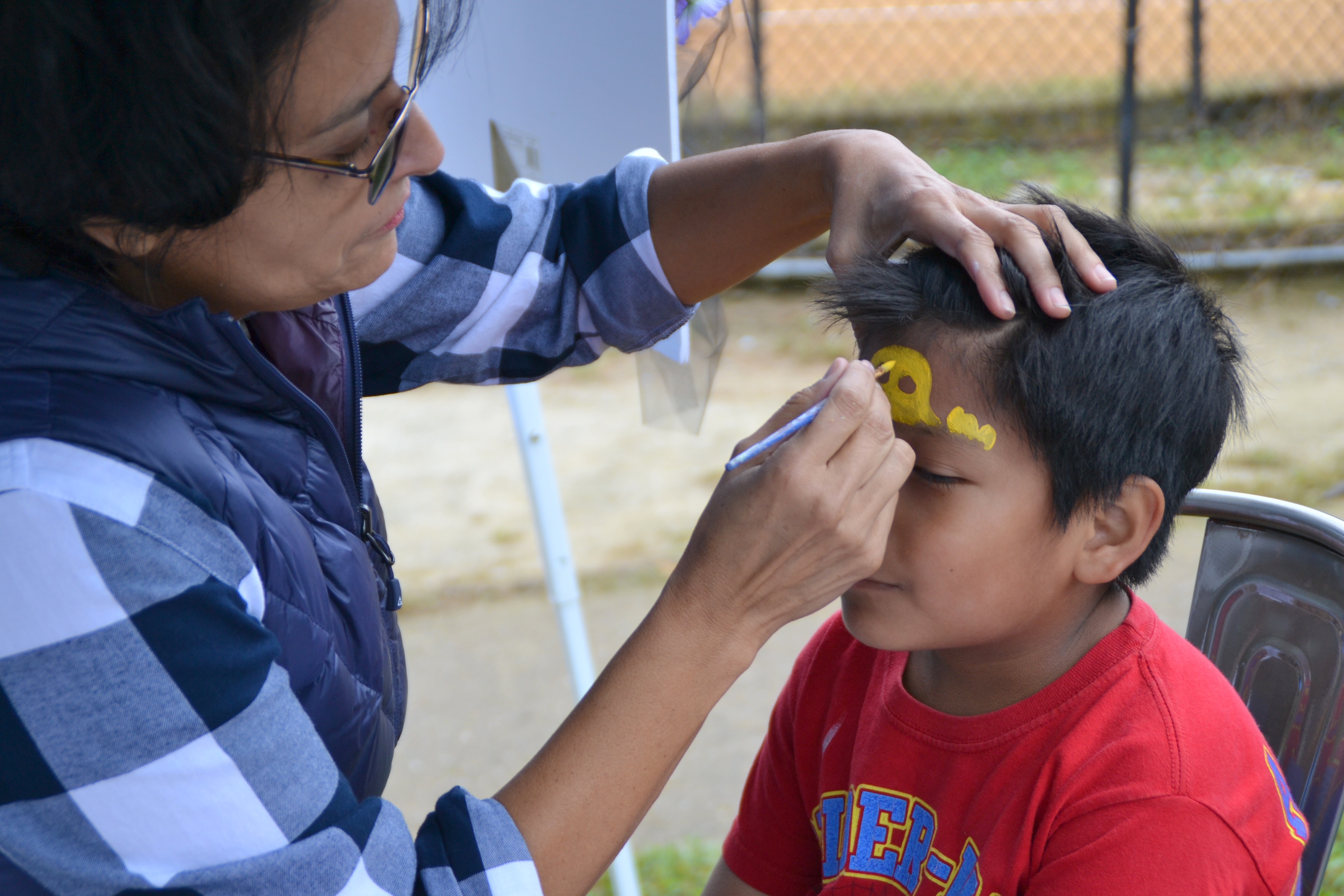 Volunteer face painting at Imagine Festival