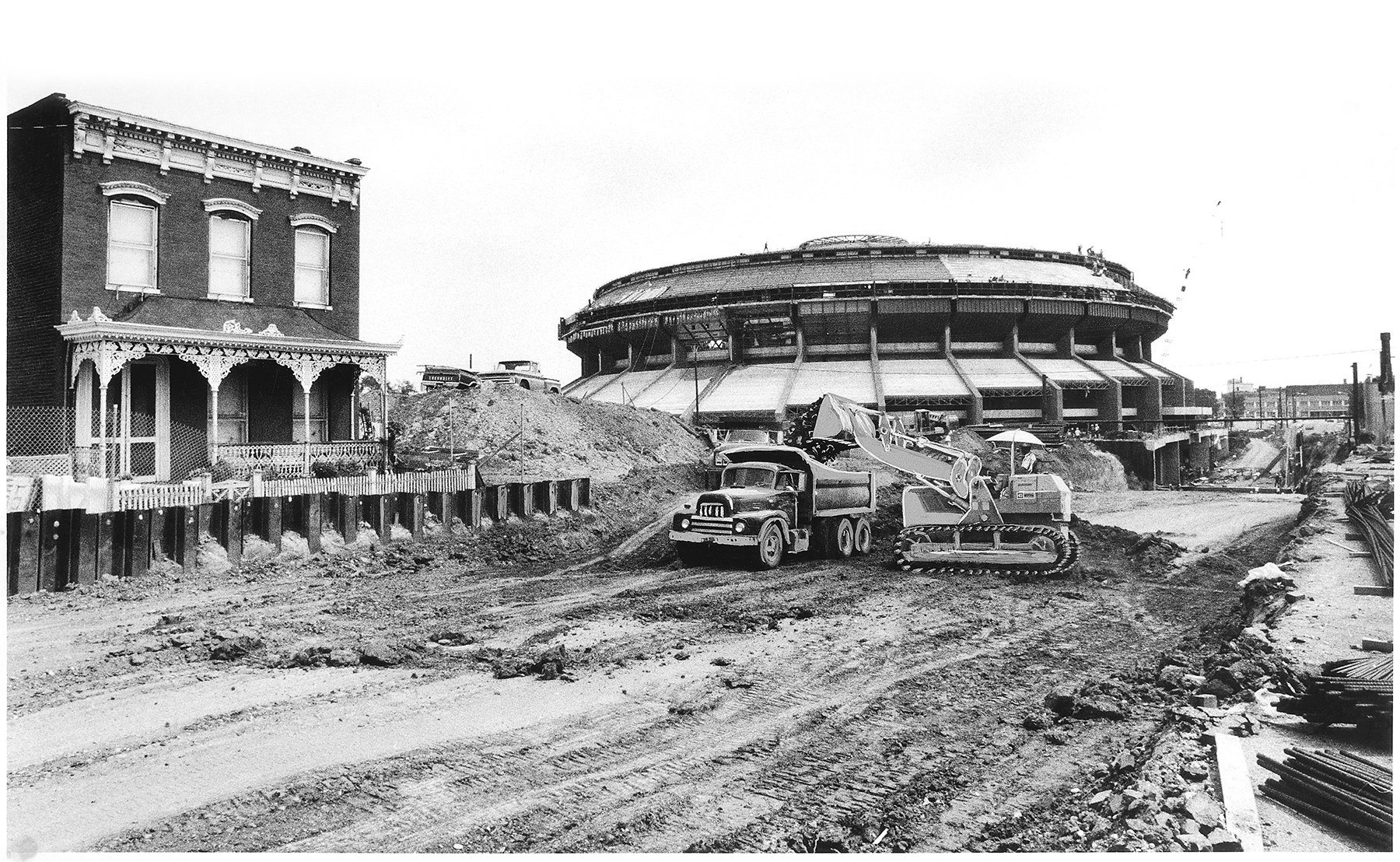 This image is a black and white photo with a 1950s style truck and construction equipment doing work near the coliseum in RVA 
