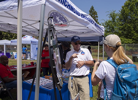 Staff talk with attendee at Multicultural Fest 2023