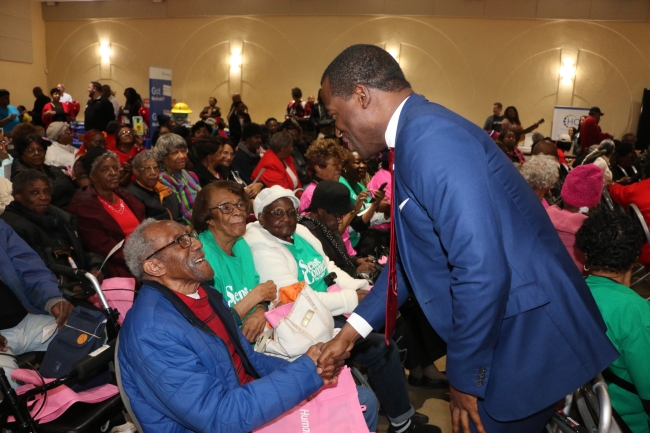 Mayor Stoney shakes the hand of a centenarian.